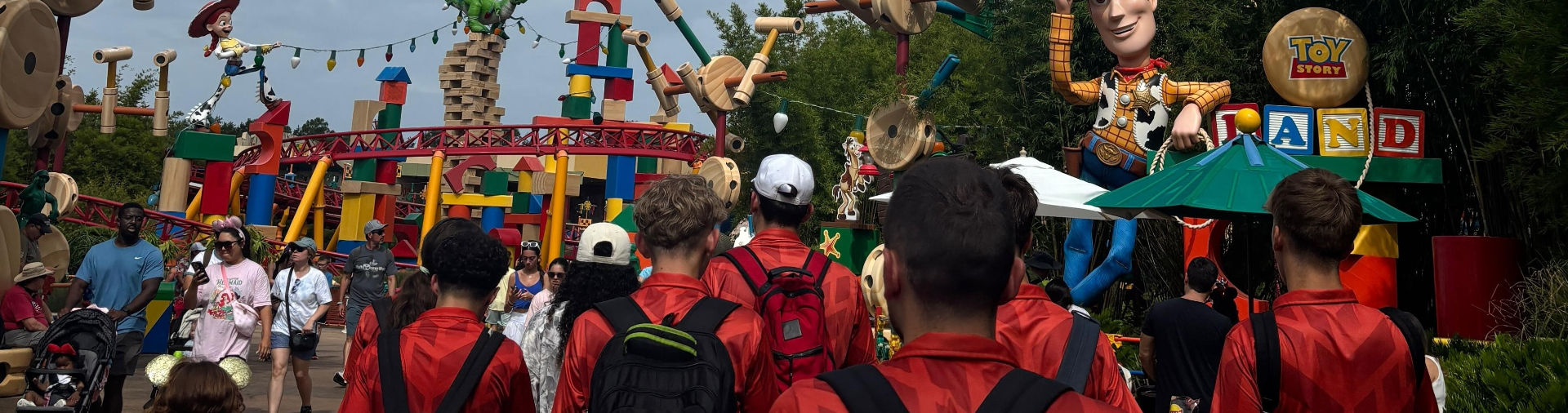 Los jugadores caminando de espaldas por Toy Story Land durante una salida del campus